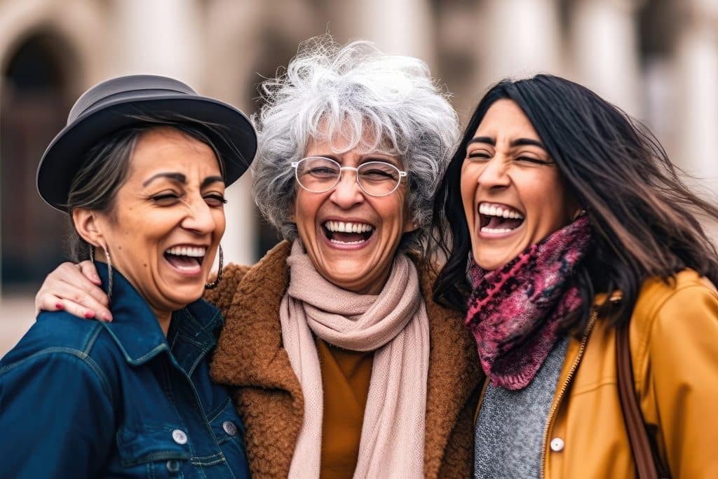 Multiracial senior women having fun together outdoor at city street- three happy mature trendy female friends hugging and laughing on urban place- Friendship lifestyle concept. Generative AI