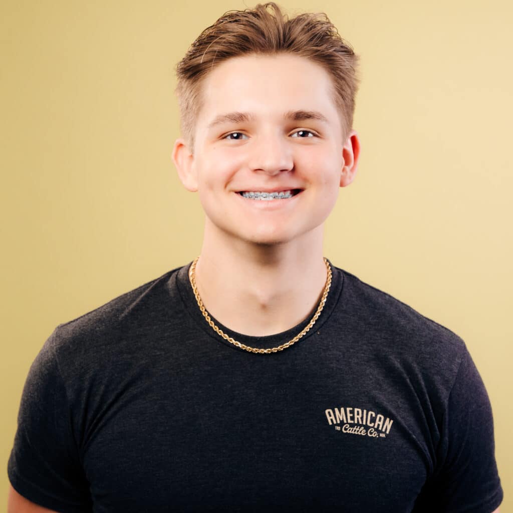 smiling young man in white shirt against blue background,